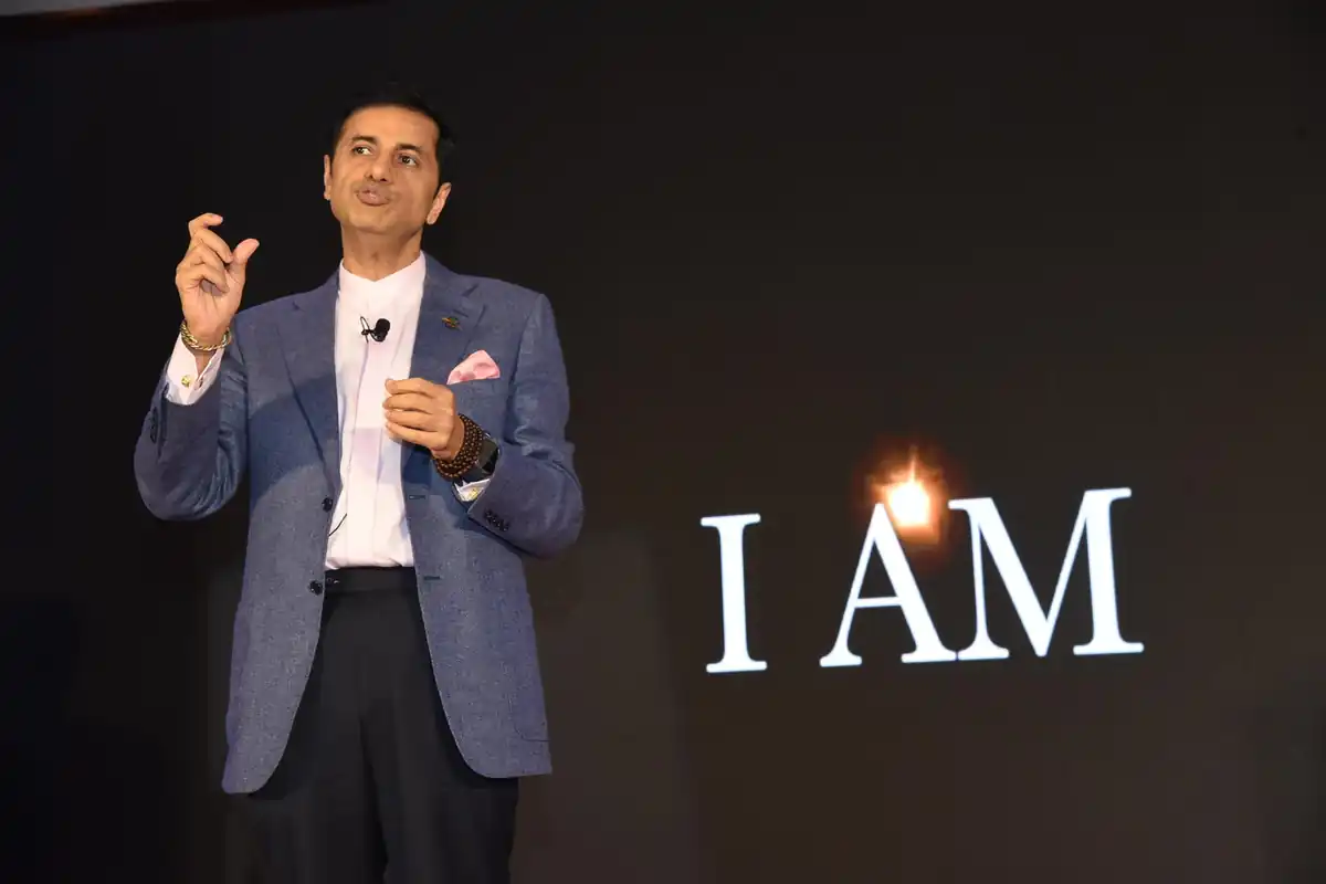 Dr. Suresh Devnani speaking on stage at a live event